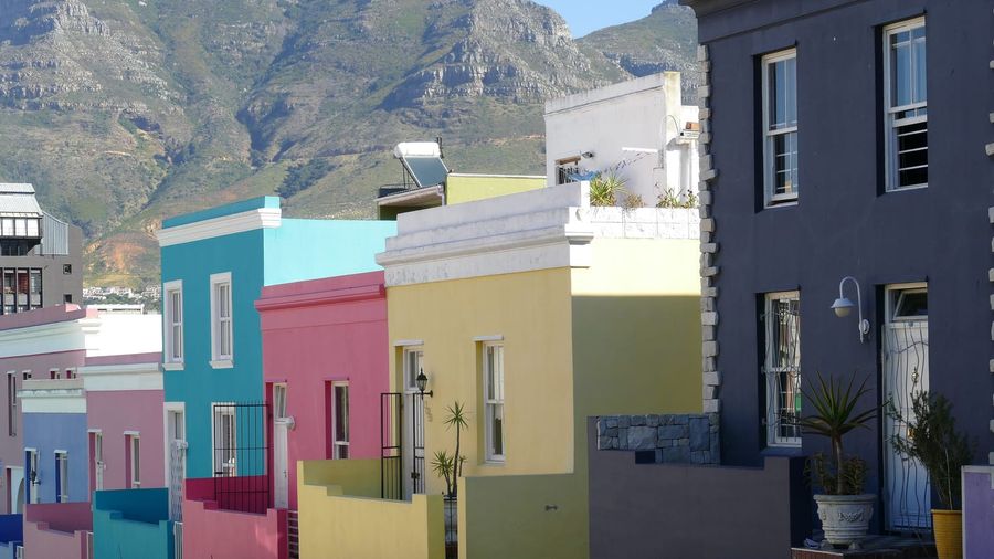 A row of brightly painted pink, blue and green houses lining a cobbled street in Cape Town's Bo-Kaap quarter