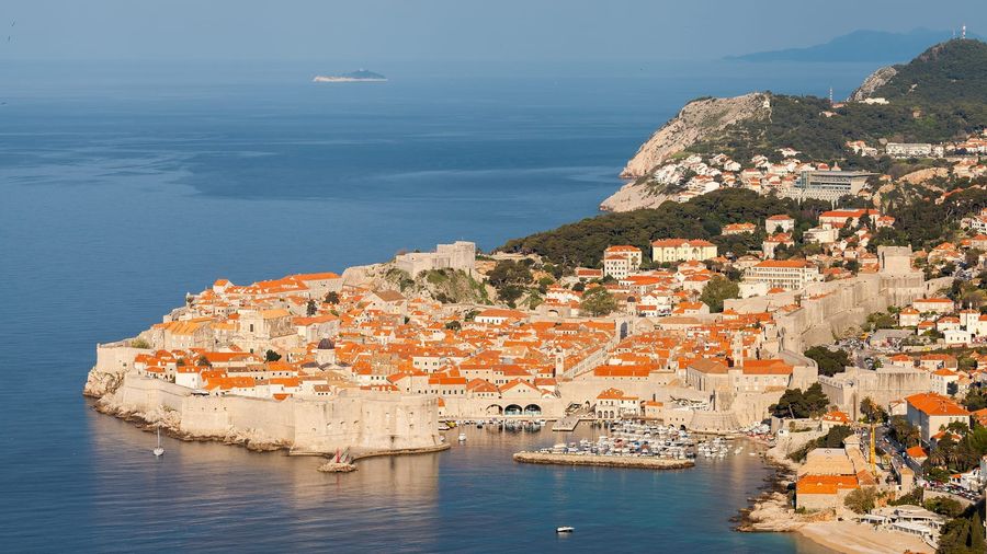 The terracotta rooftops of Dubrovnik's old town enclosed by its medieval stone walls above the Adriatic Sea
