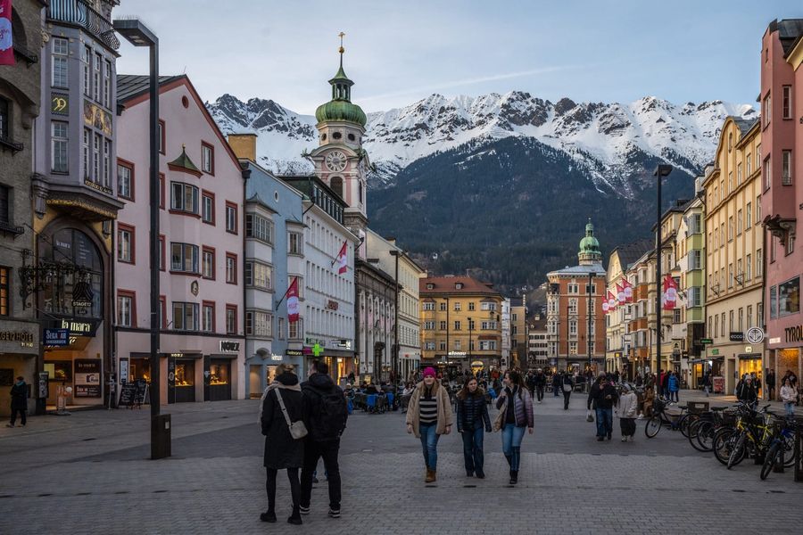 Innsbruck's baroque Maria-Theresien-Straße with pastel facades and the Annasäule column, backed by the snow-dusted Nordkette