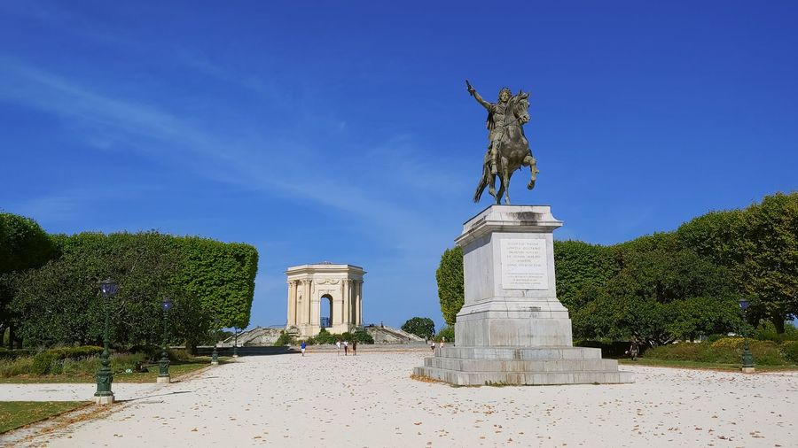 The Promenade du Peyrou in Montpellier, with its formal terraces, the Château d'Eau water tower, and the 18th-century Saint-Clément aqueduct arches beyond
