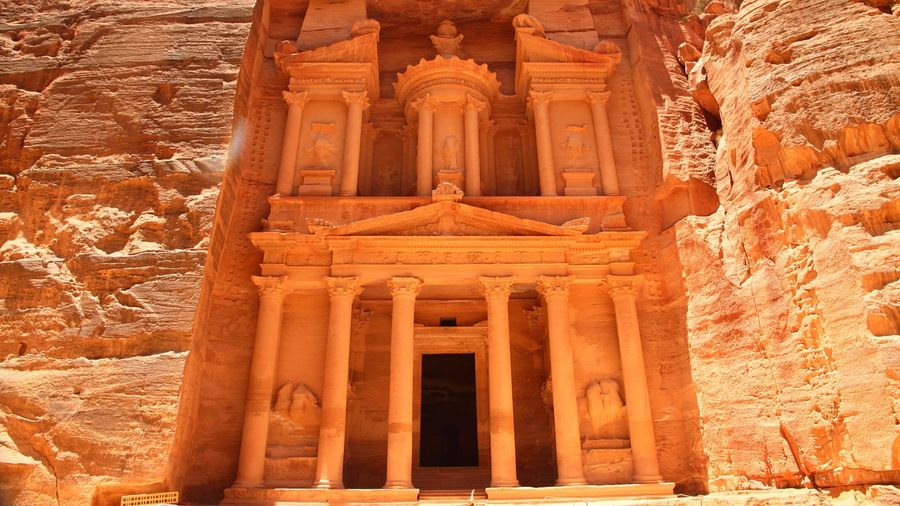 The ornate rock-cut facade of the Treasury, Al-Khazneh, glowing in the sandstone cliff at Petra, Jordan