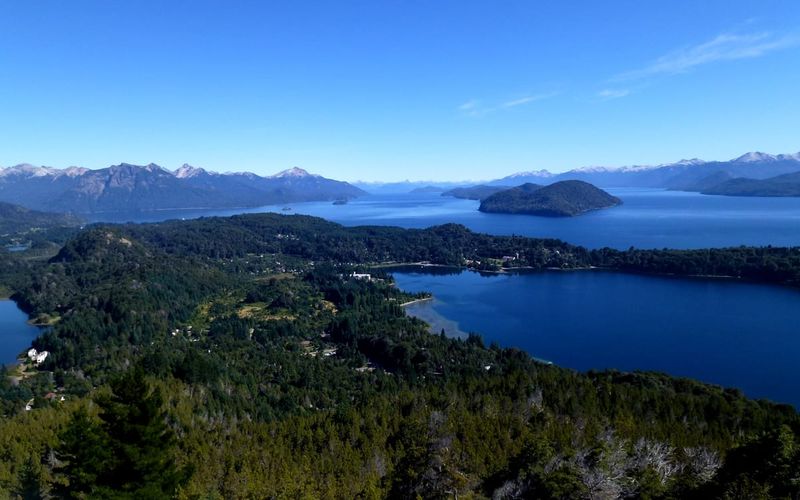 View from Cerro Campanario over the blue lakes, forested peninsulas, and snow-streaked Andean peaks of the Nahuel Huapi region near Bariloche, Patagonia