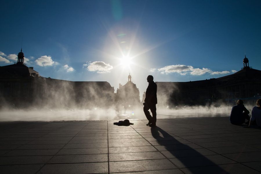 The Place de la Bourse reflected in the Miroir d'eau water mirror on the Garonne quays in Bordeaux at dusk